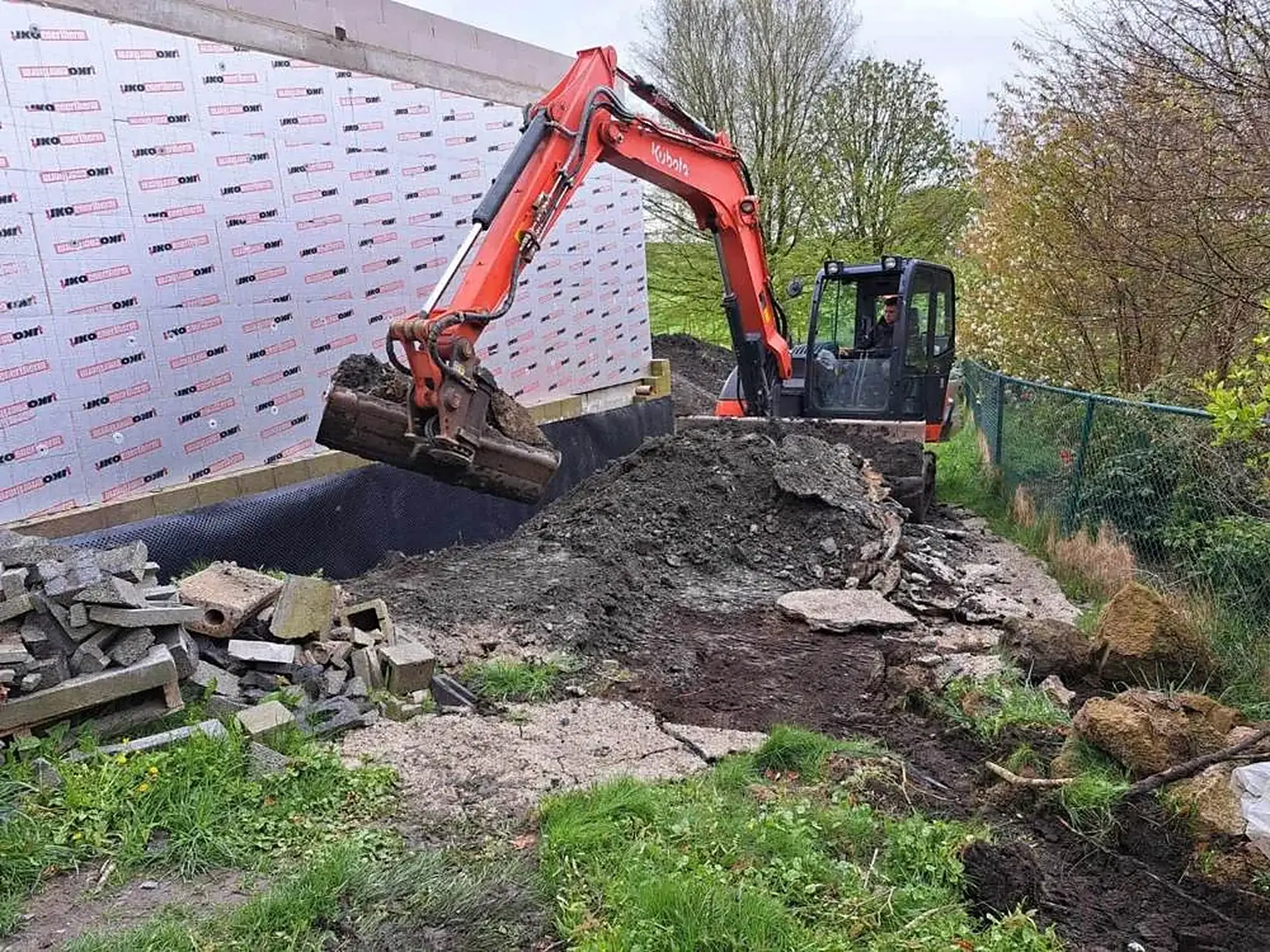 Pelle WFT en train de terrasser le long d'une maison en construction